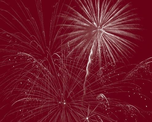 Fireworks exploding in the night sky, creating an intricate pattern of light bursts and streaks.