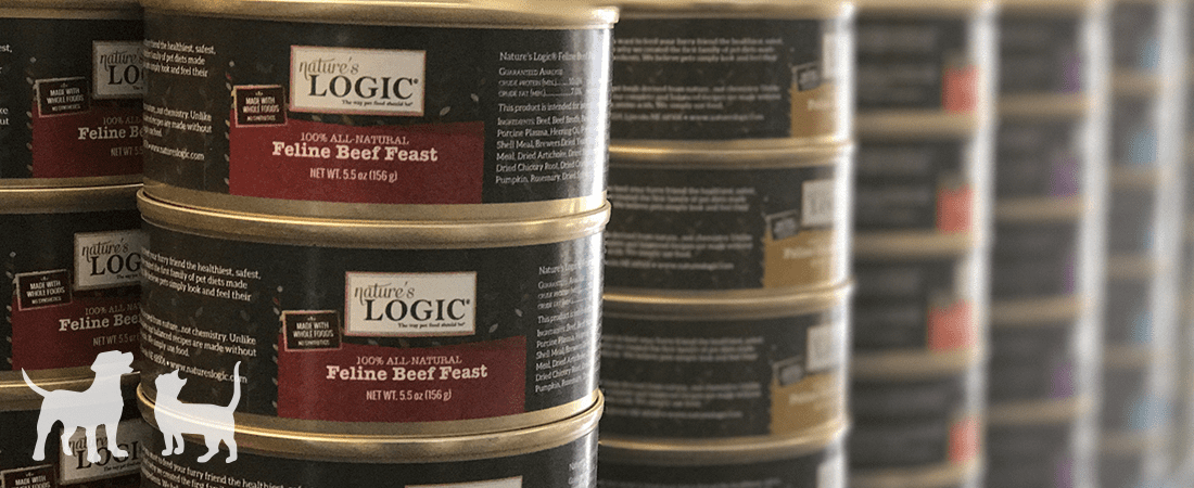 headermoiture Stack of Logic brand dog food cans with white dog silhouettes on red labels.