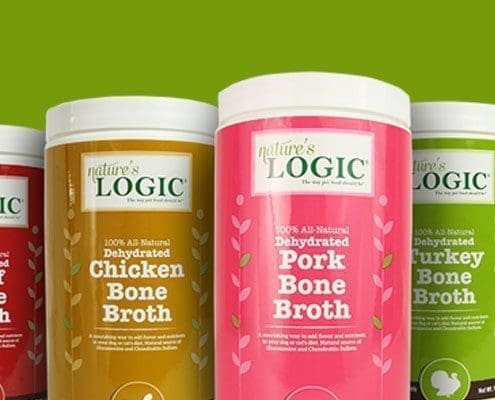 Cropped image of jars of Nature's Logic dehydrated bone broths against a green background.